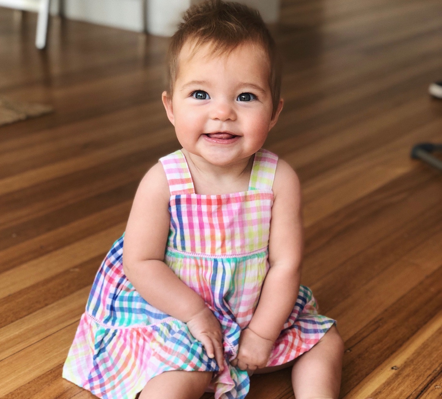 toddler girl in dress on floor smiling