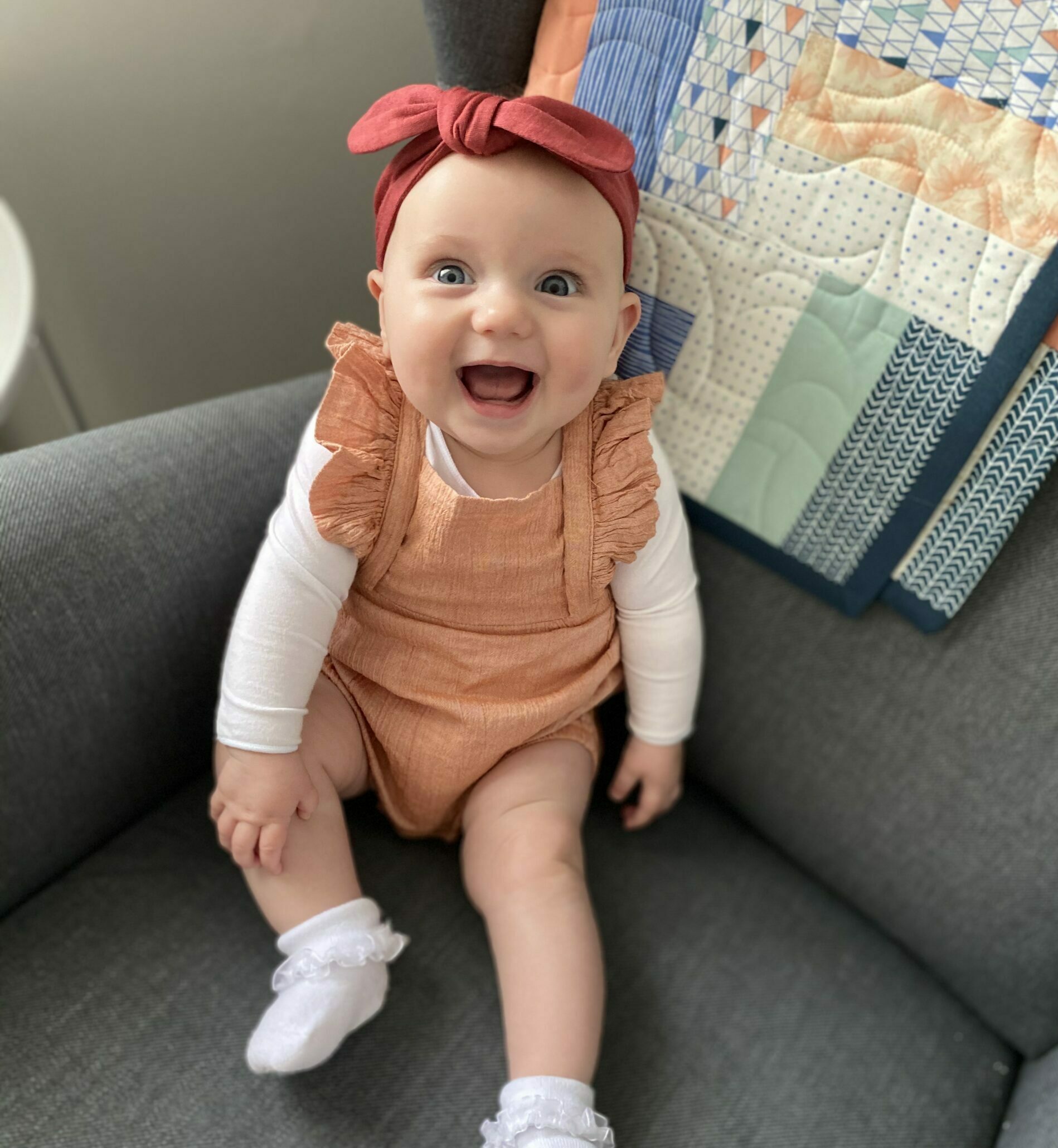 happy baby girl smiling on couch
