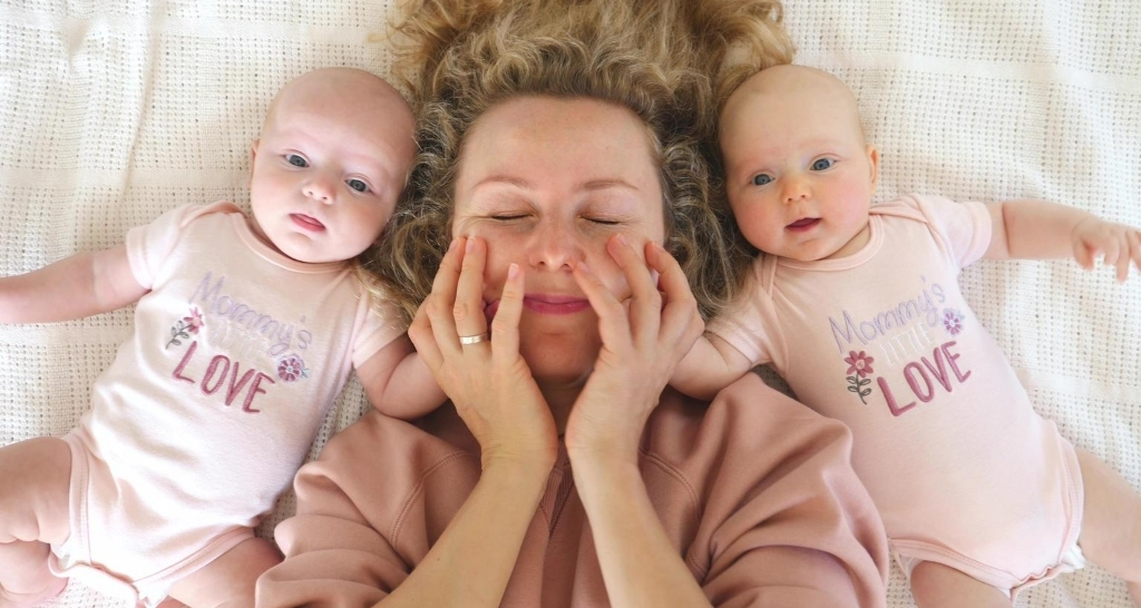 mom lying between twin babies